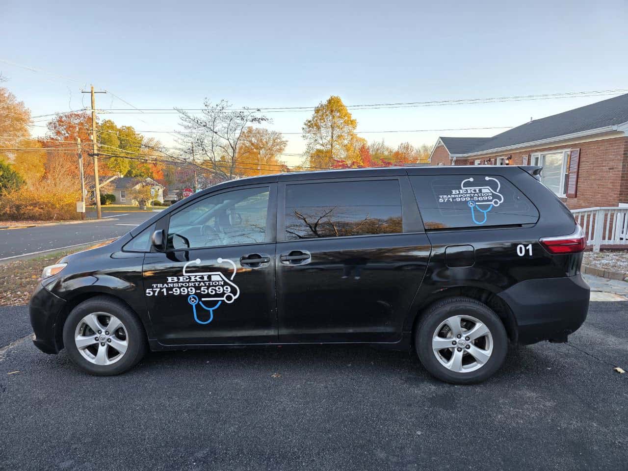 Beki Medical Transportation black van with company logo and contact info.